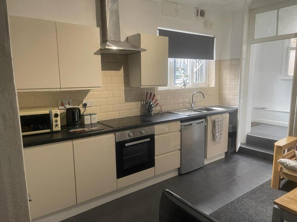 een keuken met witte kasten en een fornuis met oven bij Lovely Getaway Apartment in Wisbech in Wisbech