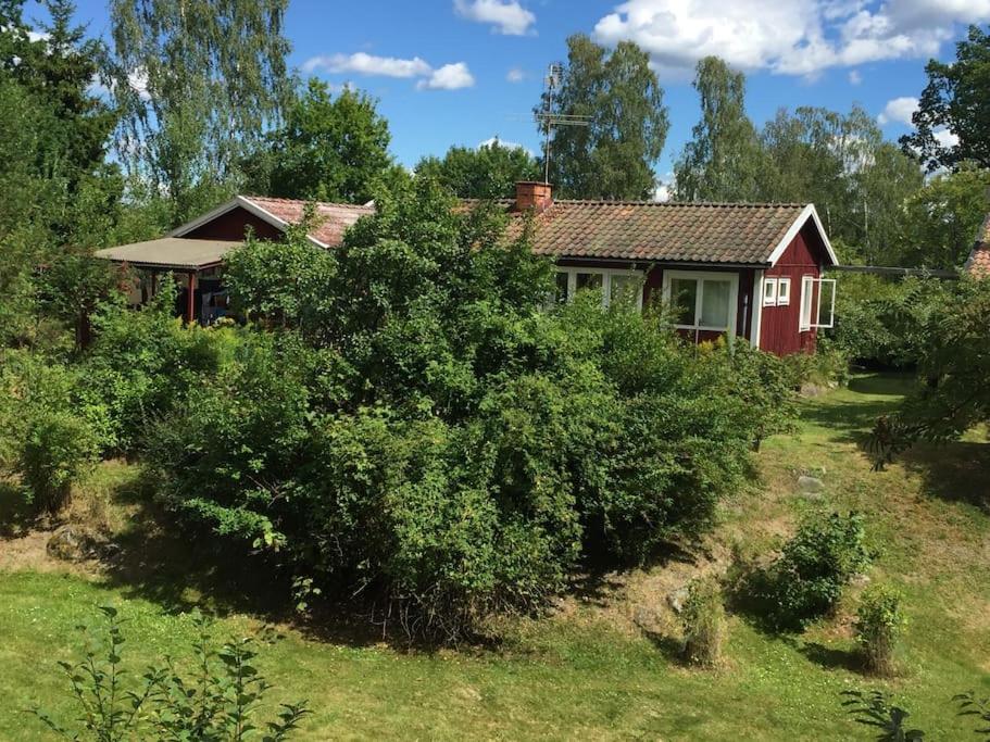 una casa roja en medio de un campo en Lättillgängligt och trevligt hus en Trosa