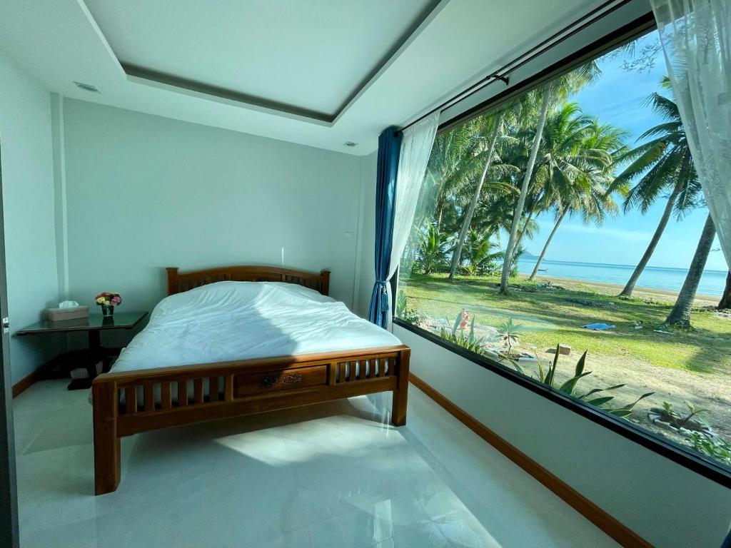 Schlafzimmer mit einem Fenster mit Meerblick in der Unterkunft บ้านระเบียงเลหลังสวน 1 ห้องริมทะเล in Ban Hin Sam Kon