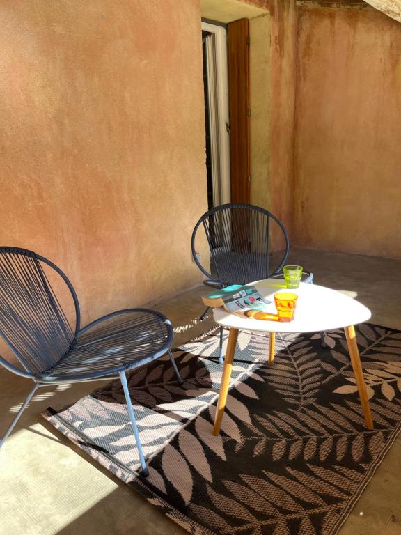 two chairs and a table on a patio at Maison de village in Lédenon