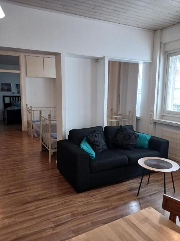 a living room with a black couch and a table at Anne's City Apartment in Jyväskylä