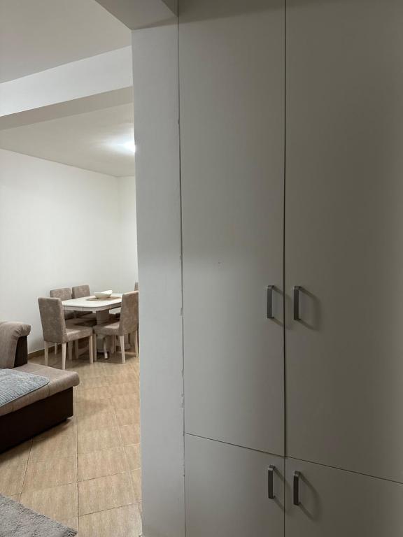 uma sala de estar com armários brancos e uma mesa em Apartman Marko em Risan