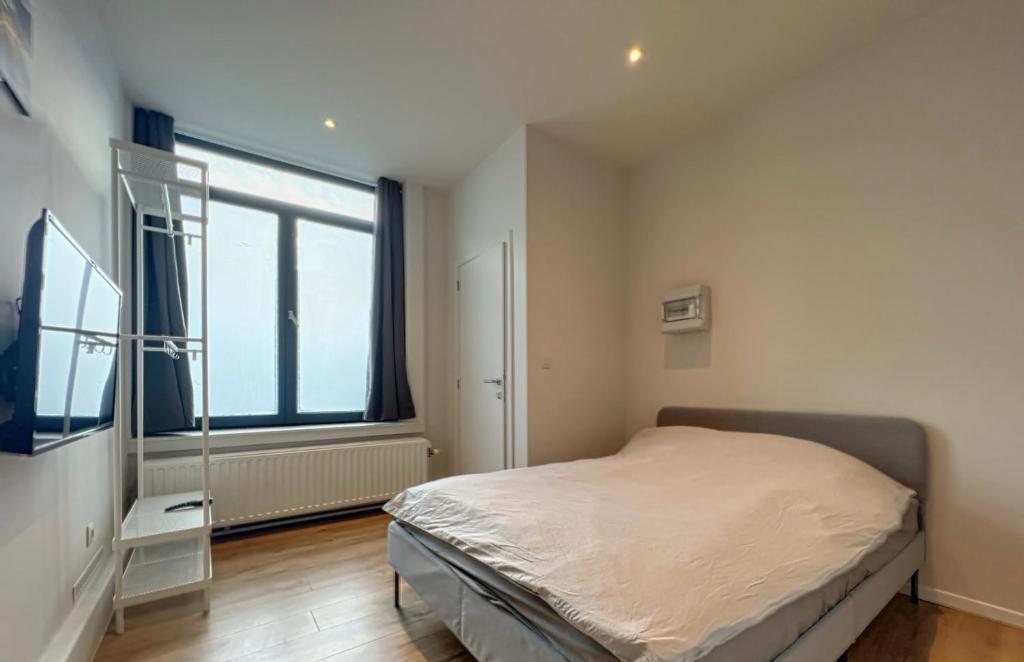 a bedroom with a bed and a large window at Station 173 B Bruxelles-Charleroi-airport in Charleroi