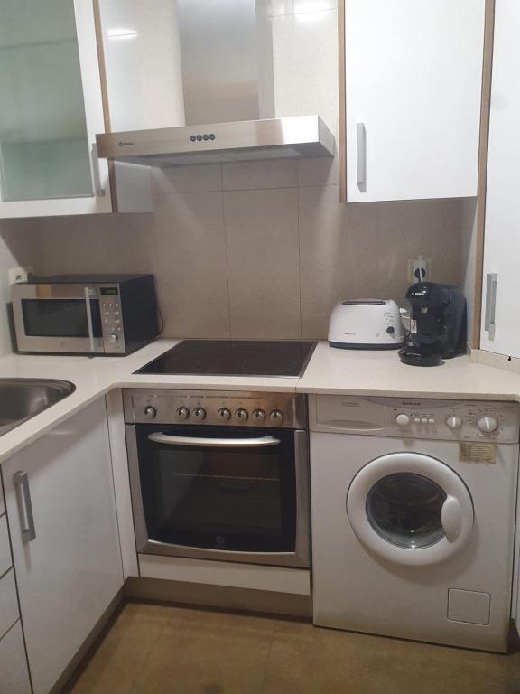A kitchen or kitchenette at Apartamento en urbanización con piscina en Playa de Silgar