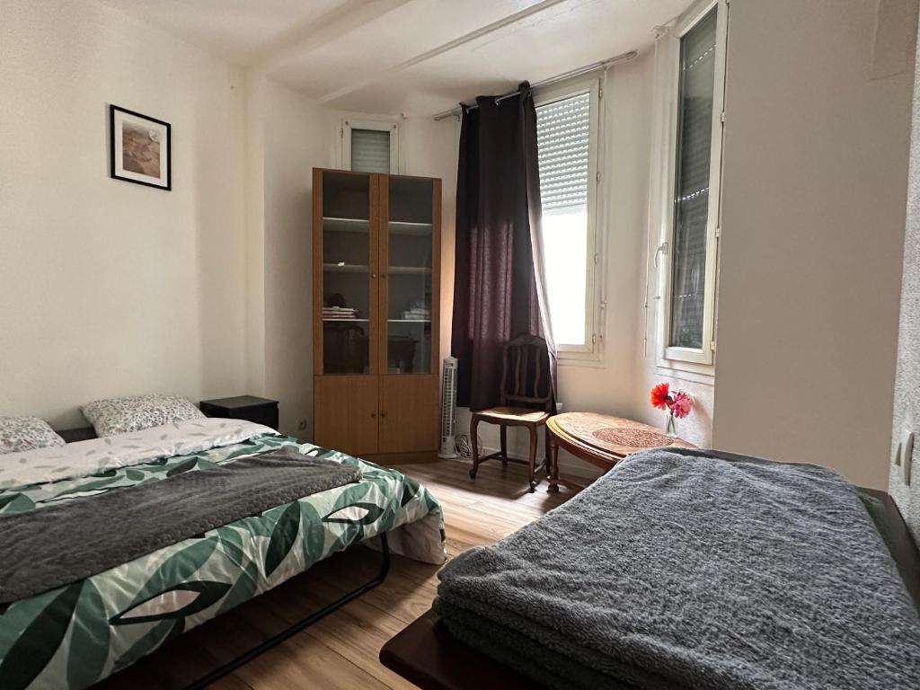 une chambre avec deux lits et une fenêtre dans l'établissement Studio Urbain Cosy-Touche Rétro, à Perpignan