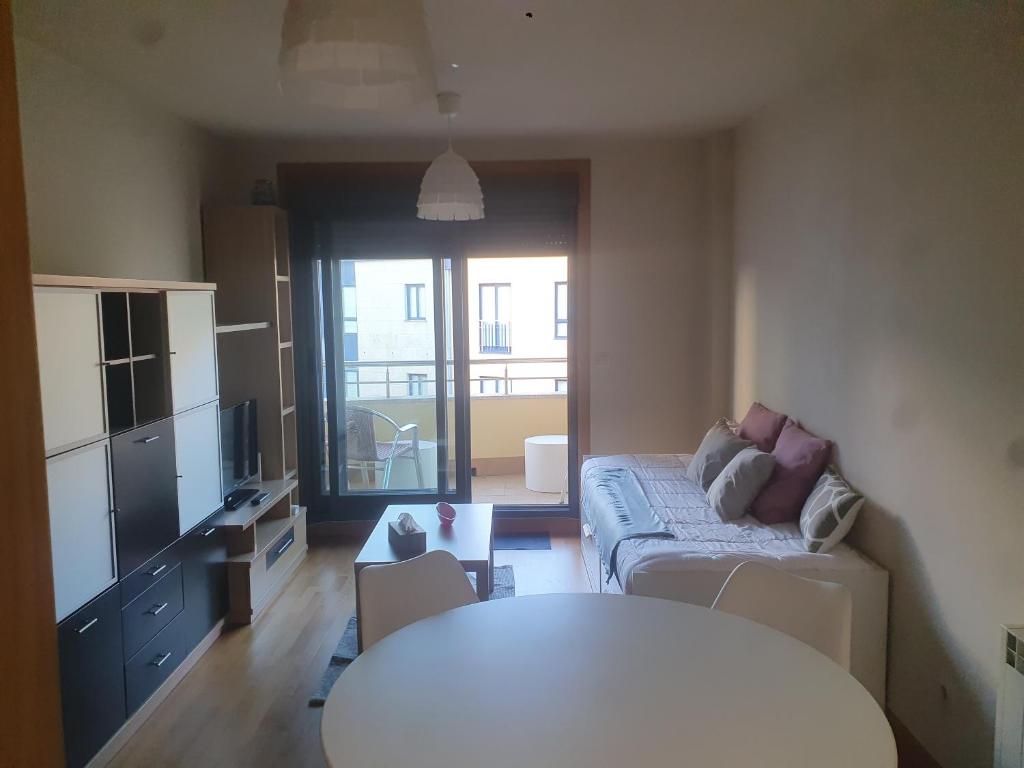 A television and/or entertainment centre at Apartamento en urbanización con piscina en Playa de Silgar
