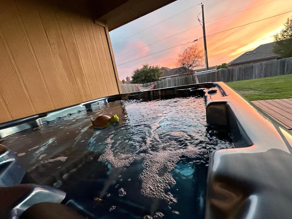 a pool with a hot tub in a backyard at Sunset Zen Space in Killeen