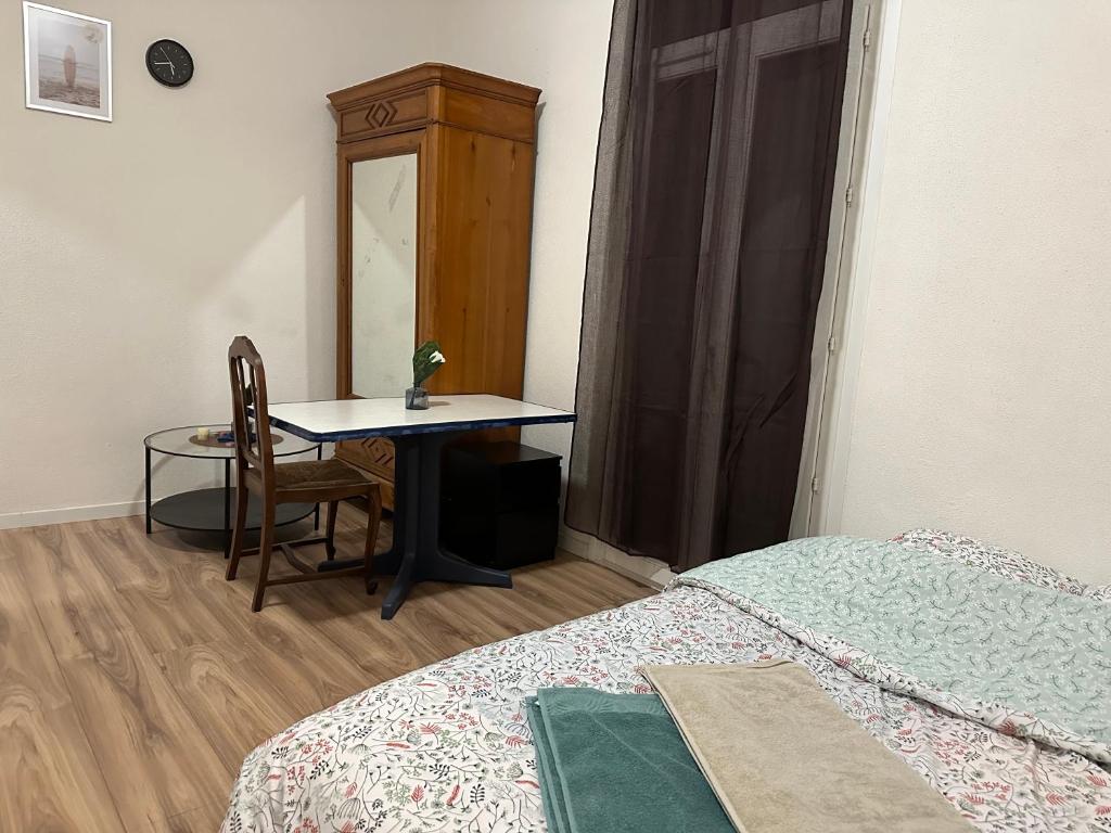 1 dormitorio con escritorio, mesa y cama en Votre Havre de Paix à Perpignan en Perpiñán