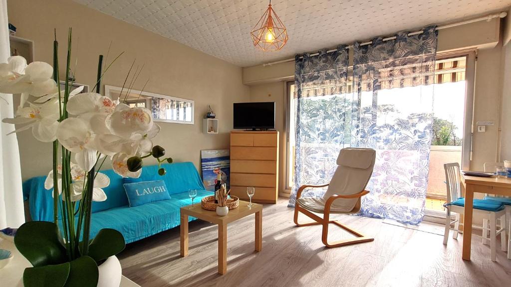 - un salon avec un canapé bleu et une table dans l'établissement Vaux sur Mer - EMPLACEMENT de CHOIX - APPARTEMENT - PLAGE de NAUZAN, à Vaux-sur-Mer