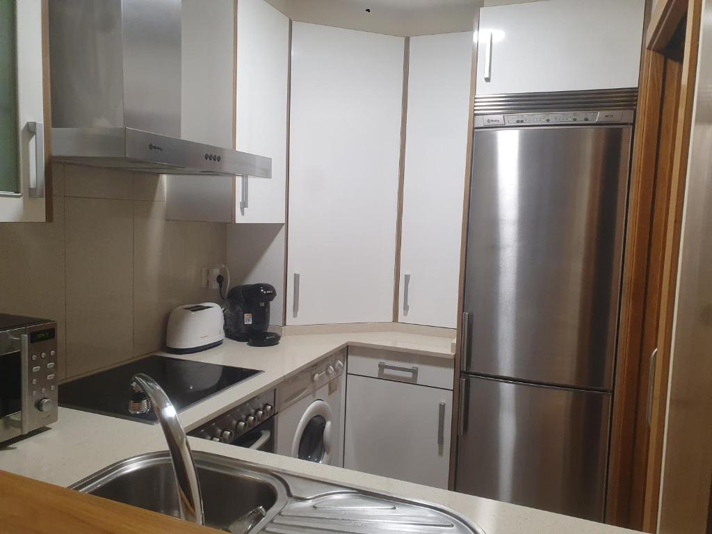 A kitchen or kitchenette at Apartamento en urbanización con piscina en Playa de Silgar