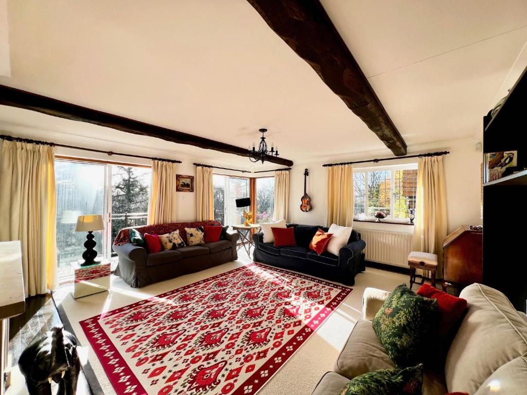 芬赫斯特的住宿－Hilltop walkers paradise with a view, sleeps 10，一间客厅,地板上铺有红色的大地毯