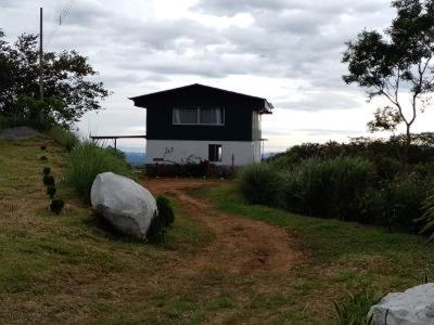 une petite maison noire et blanche sur une colline dans l'établissement Butterfly Dance (house, studio, cabin), San Ramon, à Santiago