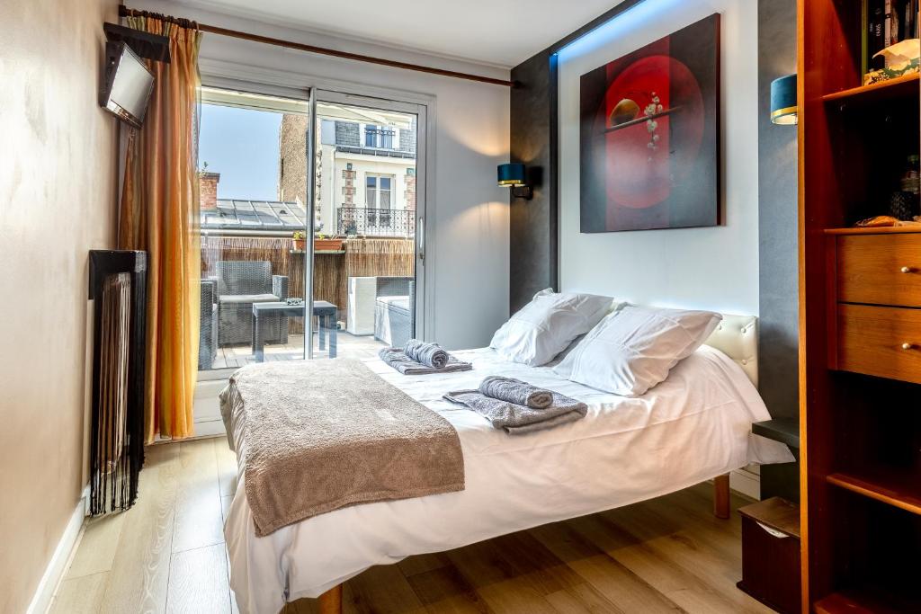 a bedroom with a bed and a large window at Chambre d'Amis - Chambres d'Hôtes-B&B-Guest House in Paris