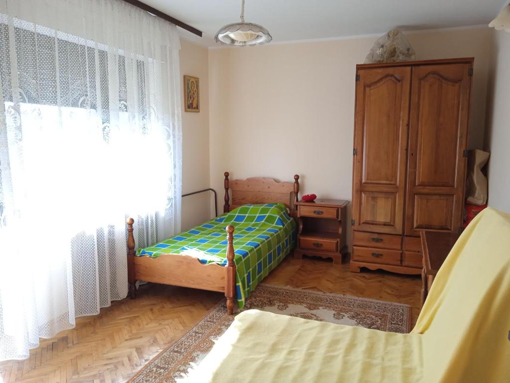 - une chambre avec 2 lits, une commode et une fenêtre dans l'établissement Kuća za odmor Matić, à Kragujevac