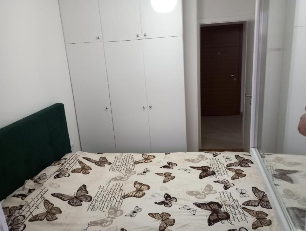 ein Bett mit einer Decke mit Schmetterlingen drauf in der Unterkunft Apartman City BL in Banja Luka