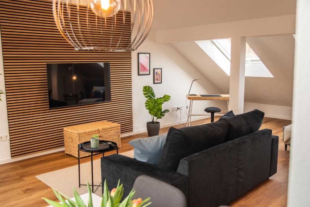 sala de estar con sofá y TV en Das RAUM-Wunder mit Küche und Smart-TV, en Karlsruhe