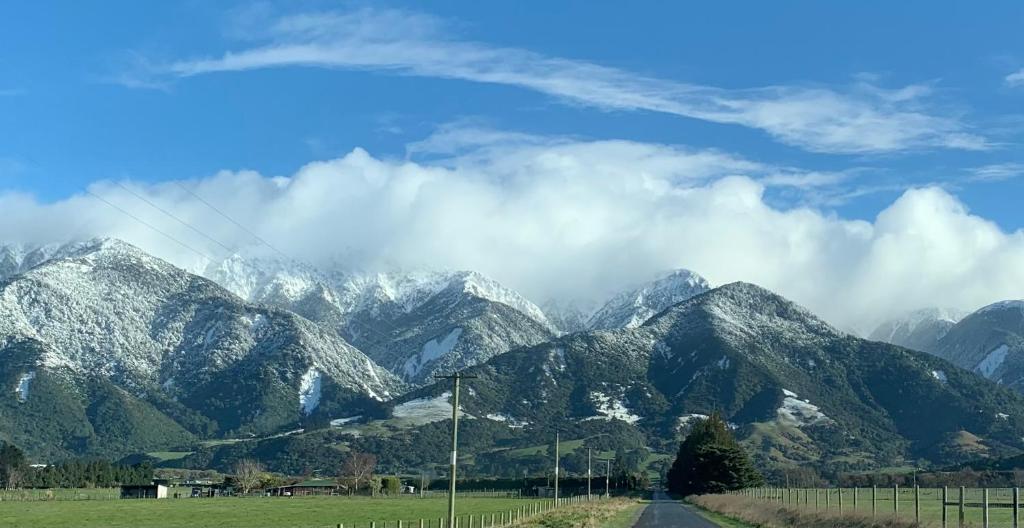 uma vista para uma serra com montanhas cobertas de neve em Alpine Manuka View Cabin em Kaikoura