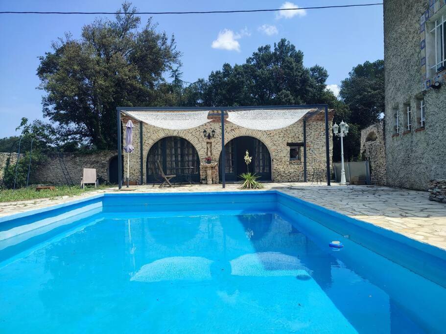 een blauw zwembad voor een gebouw bij Petite maison indépendante in Nîmes