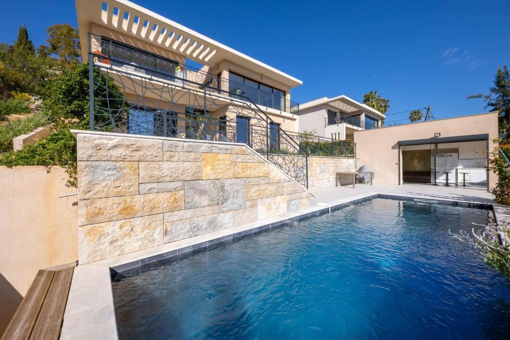 une piscine devant une maison dans l'établissement 06BK - Superb contemporary sea-view villa, à Cagnes-sur-Mer