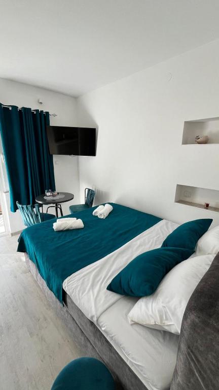 a bedroom with two beds with blue and white pillows at STR Apartment in Tivat