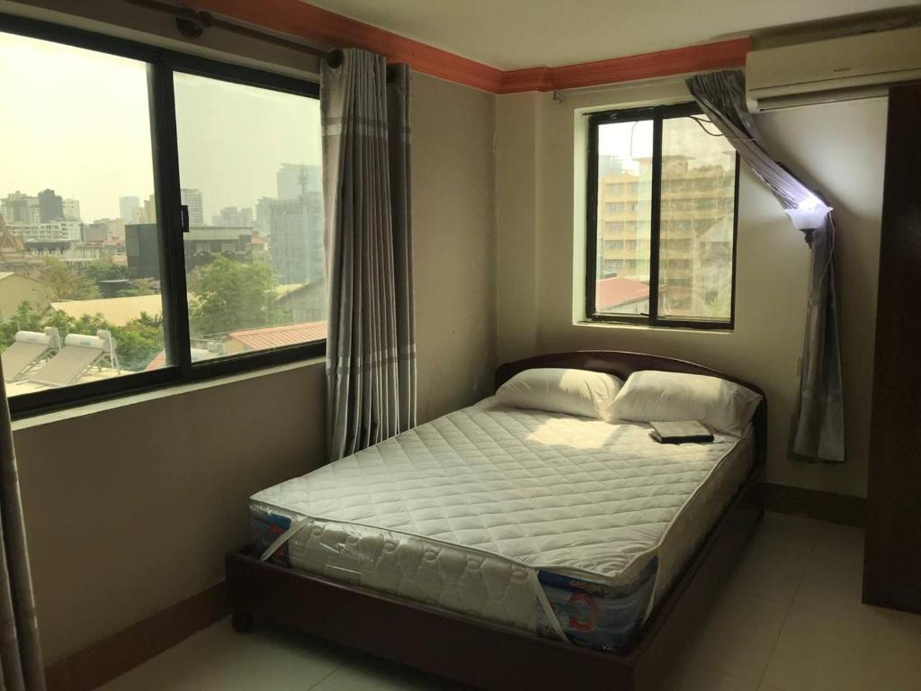 Cama pequeña en habitación con 2 ventanas en RS Galaxy HOTEL en Phnom Penh