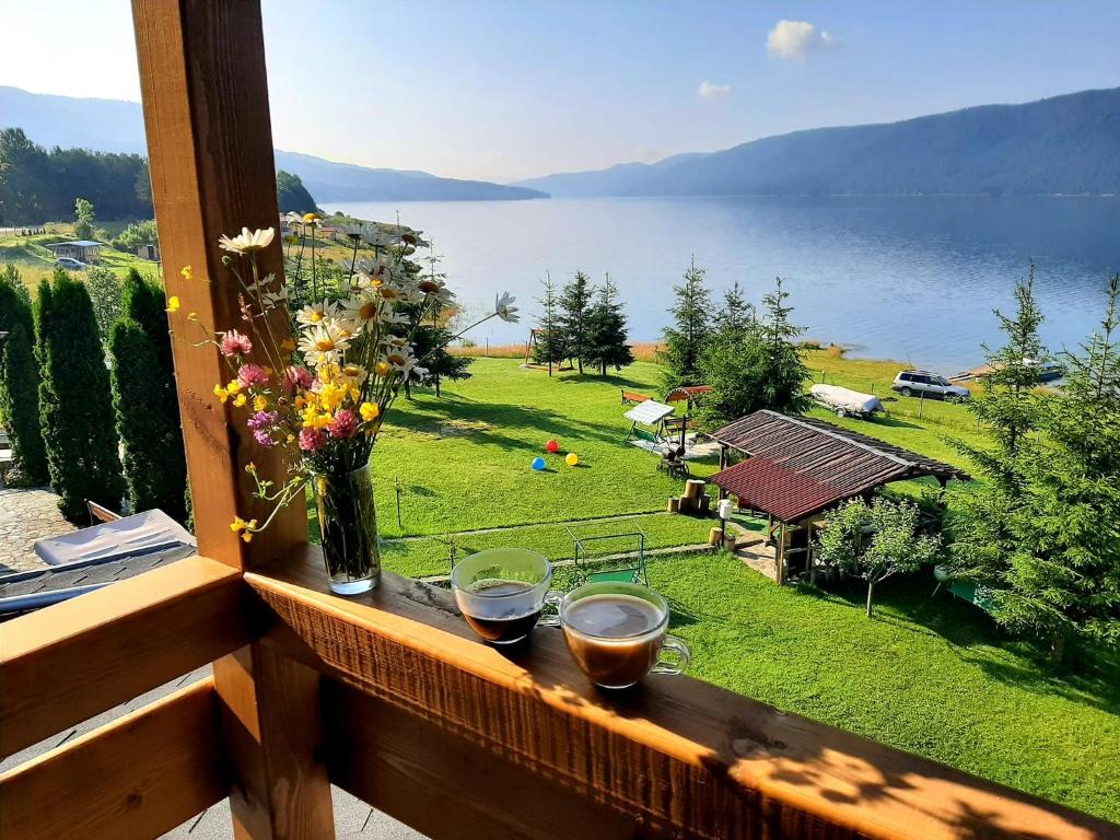 a balcony with a view of a lake and a garden at ЕДЕЛВАЙС Сърница in Sarnitsa