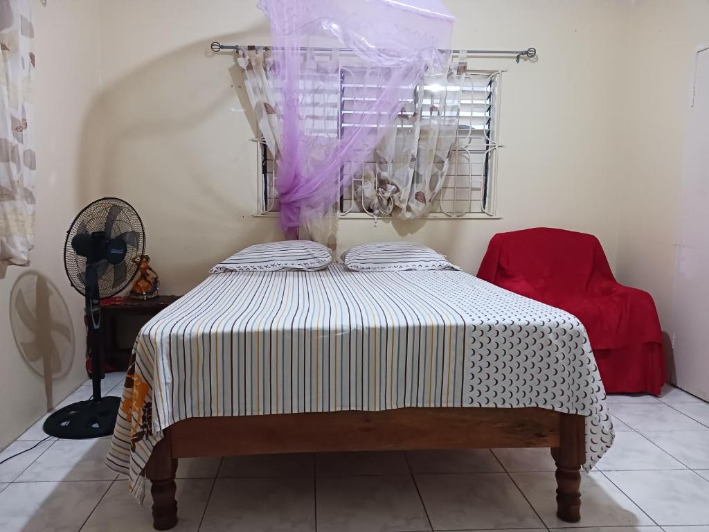 a bedroom with a bed with a white and black blanket at Tina's Guest House in Ocho Rios