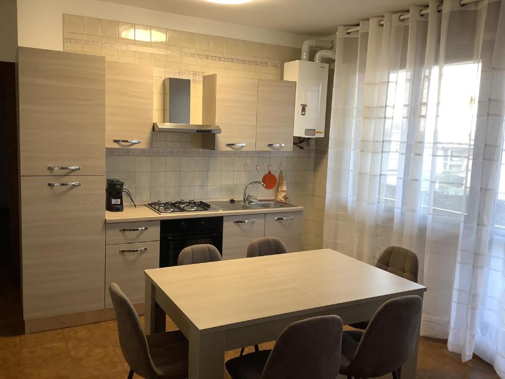 - une cuisine avec une table, une table et des chaises dans l'établissement Appartamento Dannunzio, à Castelnuovo del Garda