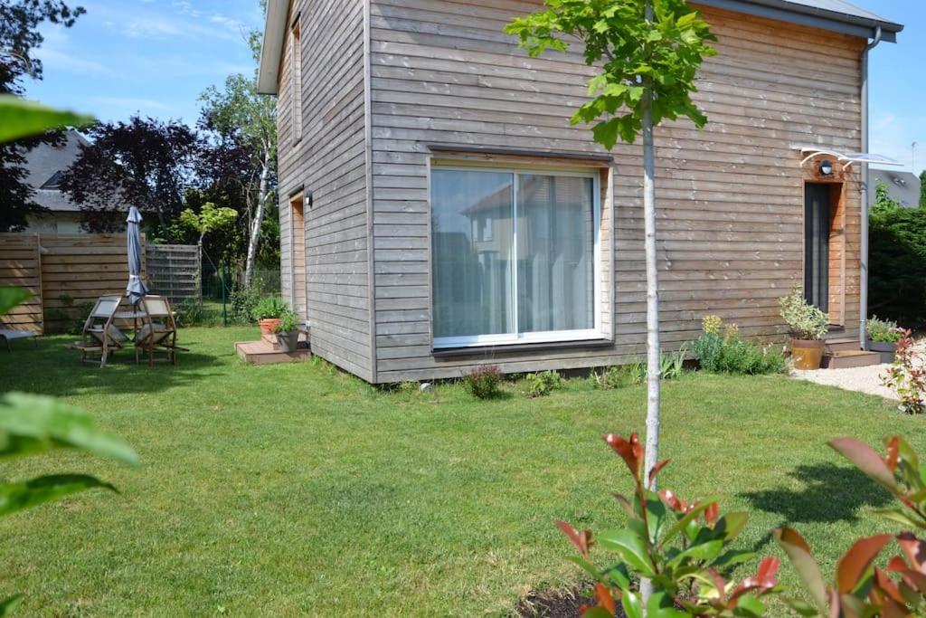 ein Haus mit einem Hof mit einem Tisch und einem Fenster in der Unterkunft La maison Des Cordelles in Saint-Denis-en-Val