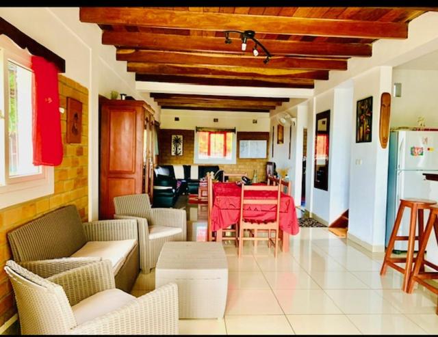 een woonkamer met een rode tafel en stoelen bij Villa baobab in Ramena