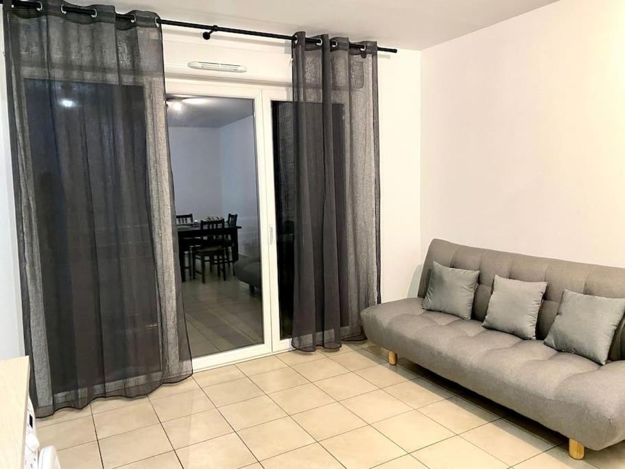 un salon avec un canapé et une table dans l'établissement Charmant T2 calme proche frontière Suisse, à Saint-Julien-en-Genevois