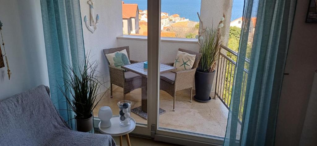 a balcony with a table and chairs and a window at Apartments Klementina in Postira