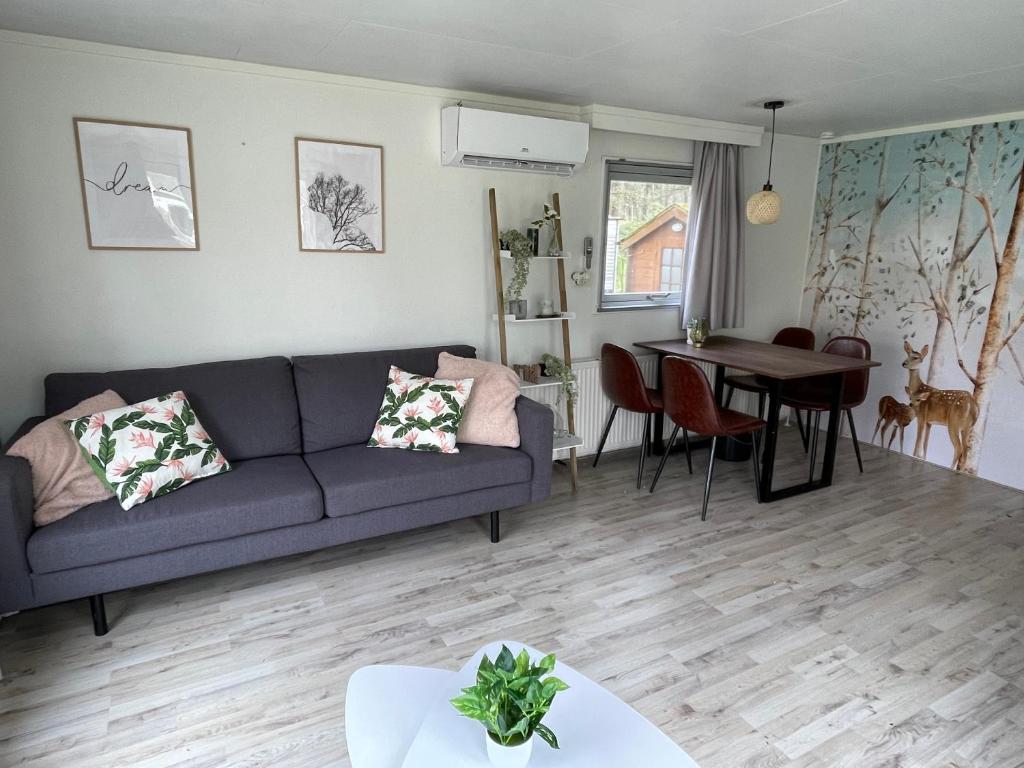 ein Wohnzimmer mit einem Sofa und einem Tisch in der Unterkunft Ecolodge Over the Rainbow in Bocholt
