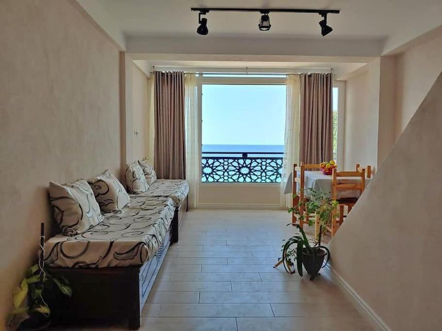 Appartement T2 avec terrasse et Vue mer à Béjaïa proche plage في بجاية: غرفة معيشة مع أريكة ونافذة كبيرة