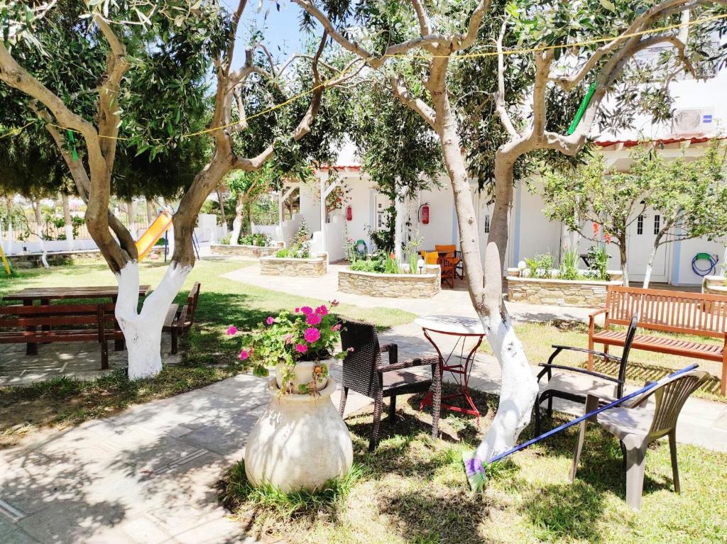 Villa Anna في أجيوس بيتروس: حديقة بها مقاعد وطاولة بها زهور في مزهرية