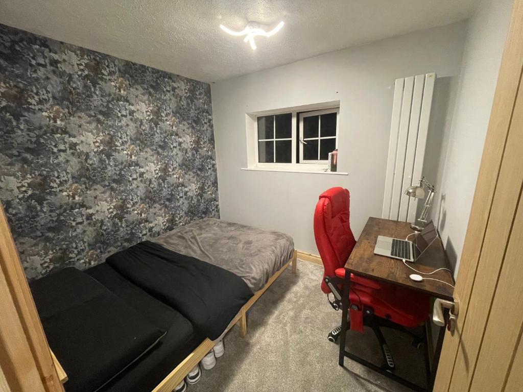 niewielka sypialnia z łóżkiem i biurkiem z laptopem w obiekcie Barwell Manor - WFH Suite w mieście Leicester