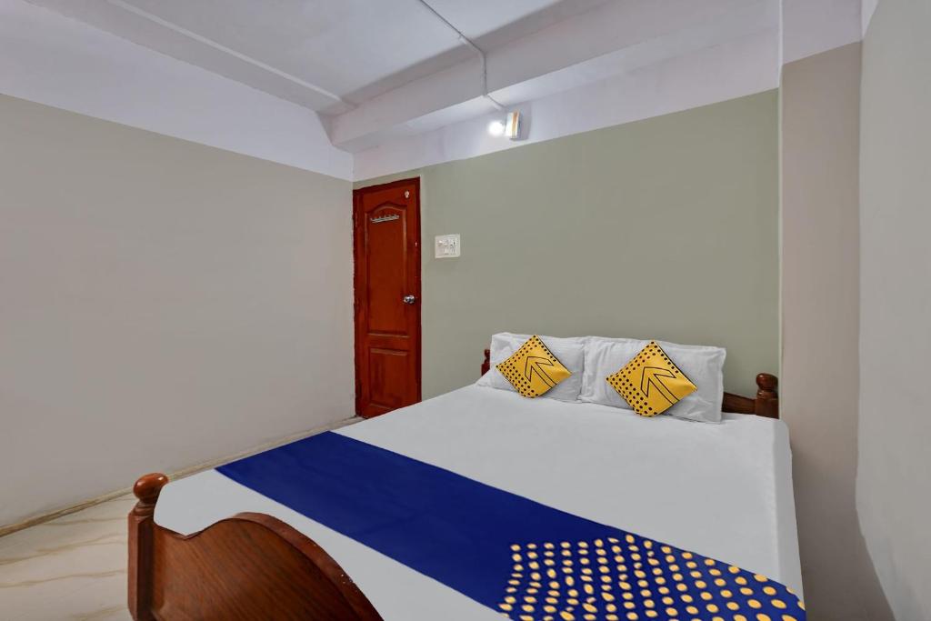 1 dormitorio con 1 cama con almohadas azules y amarillas en SPOT ON Canton Lodging And Boarding, en Bangalore