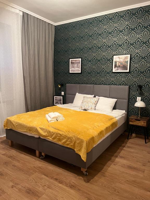 1 dormitorio con 1 cama grande con manta amarilla en Apart Och, en Varsovia