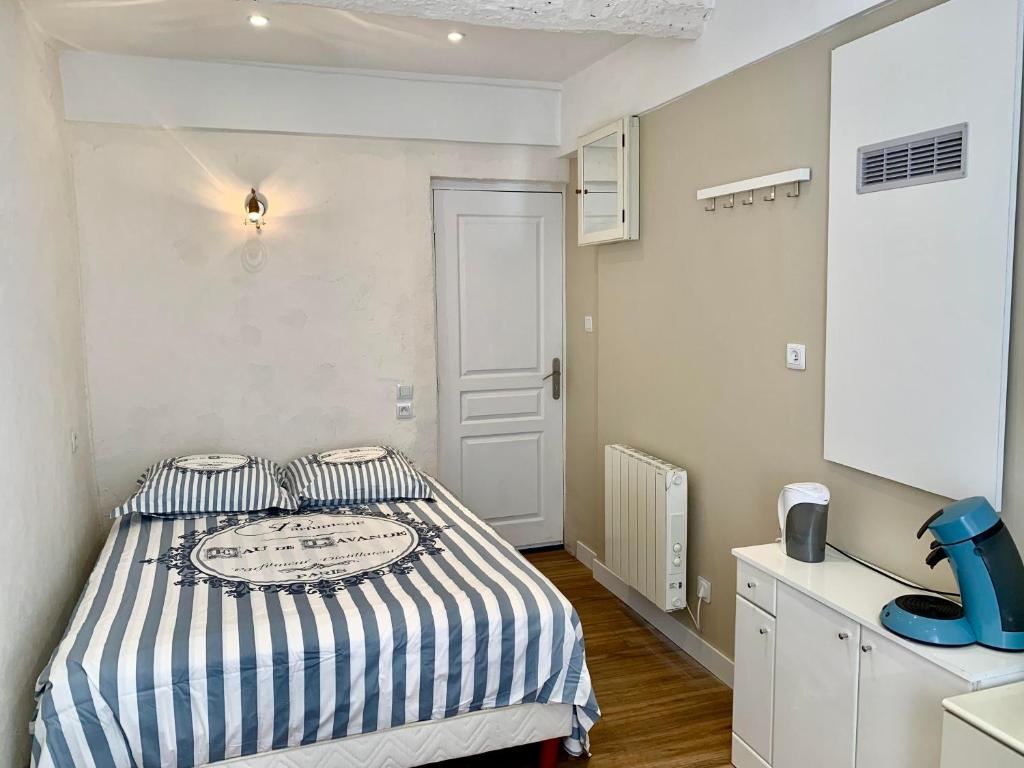 a small bedroom with a bed with striped sheets at Operappart 2 in Toulon