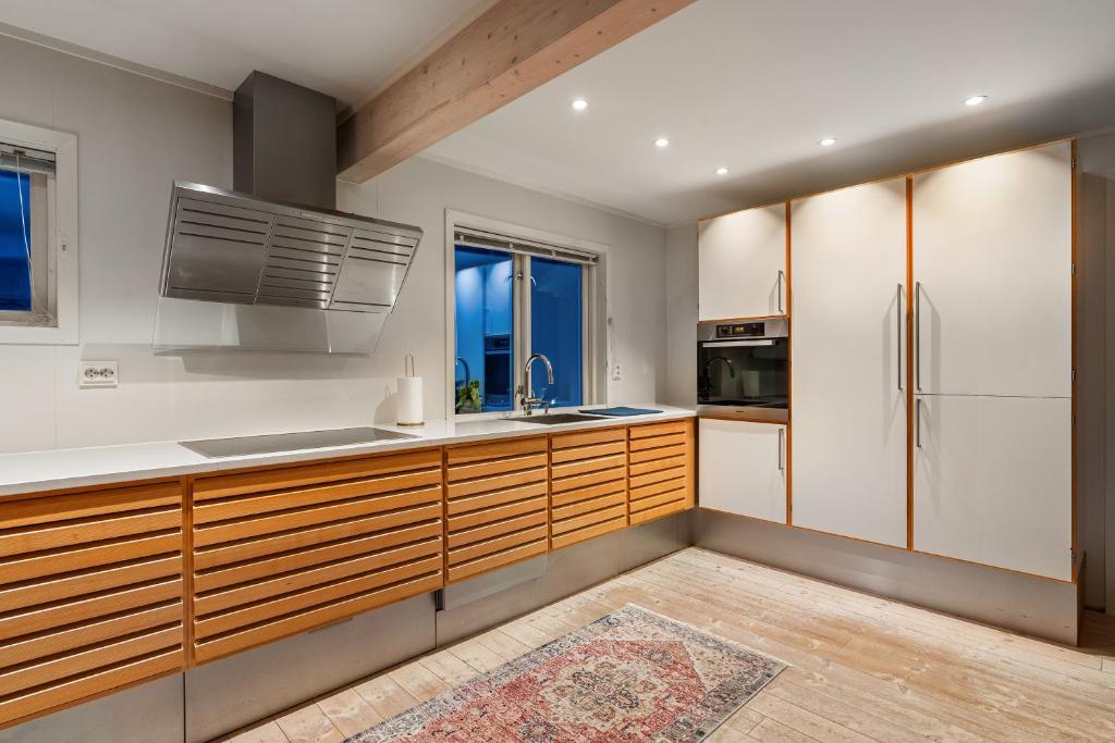 a kitchen with wooden cabinets and a refrigerator at Villa Arctica in Tromsø