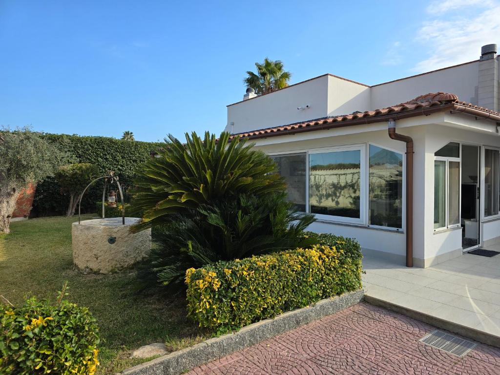 une maison avec un palmier devant dans l'établissement Syracuse Blue Sea, à Fontane Bianche