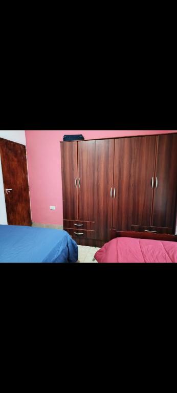 um quarto com 2 camas e armários de madeira em CASA BARBARA em Santa Elena