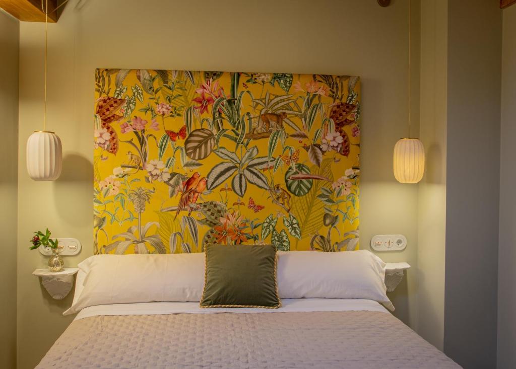 1 dormitorio con 1 cama con cabecero de flores en Las Musas, Casa Rural en Hervás