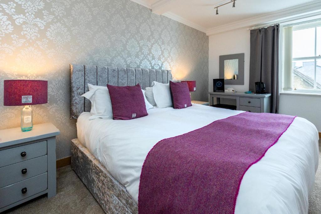 a bedroom with a large bed with a purple blanket at Stornoway Bed and Breakfast in Stornoway