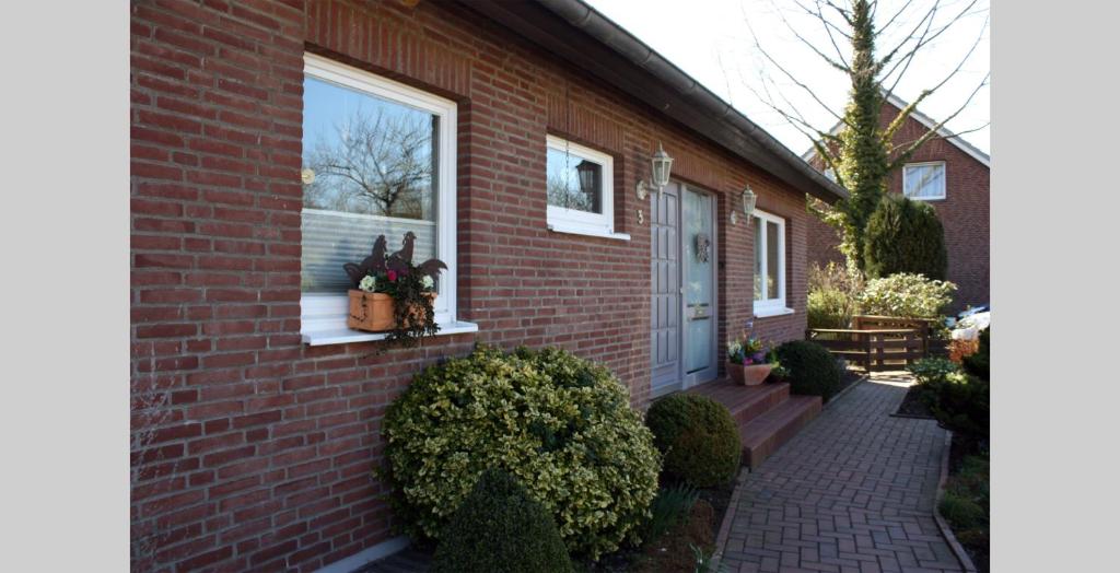 ein Backsteinhaus mit Blumen im Fenster in der Unterkunft Apartment Peters in Haffkrug