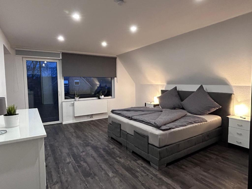 a bedroom with a large bed and a large window at Ferienwohnung Landliebe in Ihlow