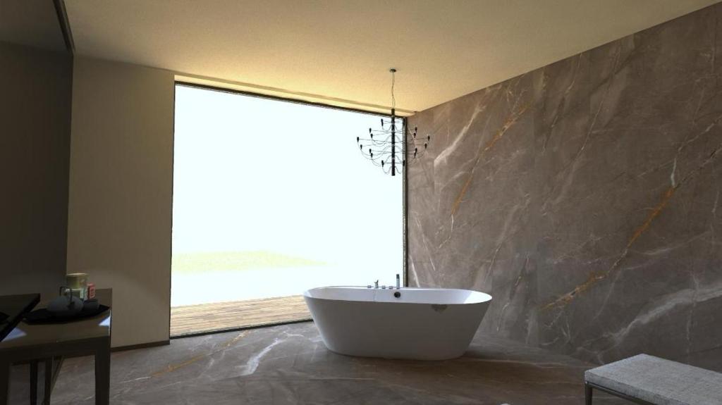 uma banheira na casa de banho com uma grande janela em Luxury Vibes Boutique Hotel & Spa em Nicolosi