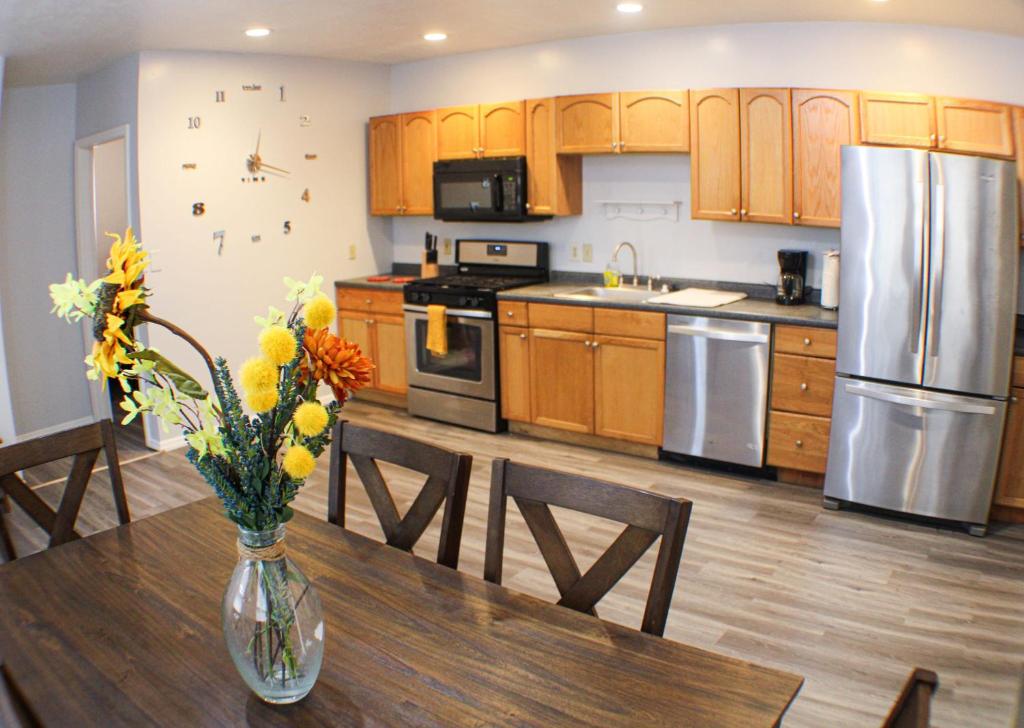 a kitchen with a table with a vase of flowers on it at 2 Bedroom East Carson Street Sanctuary in Pittsburgh