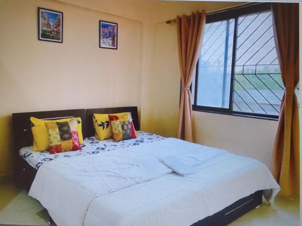 a bedroom with a large bed with a window at Affordable 1 BHK flat with High Speed Wi Fi,Kharadi in Pune