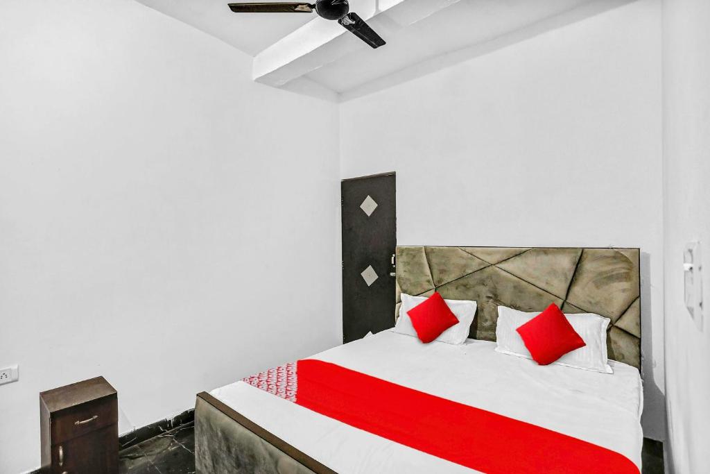 sypialnia z dużym łóżkiem z czerwonymi poduszkami w obiekcie OYO Flagship 81043 Paradise Inn w mieście Panchli